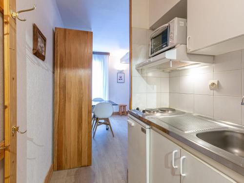 une petite cuisine avec un évier et un micro-ondes dans l'établissement Studio cosy au cœur de Val-d'Isère, pieds des pistes, accès wifi, 2 pers. - FR-1-694-74, à Val dʼIsère