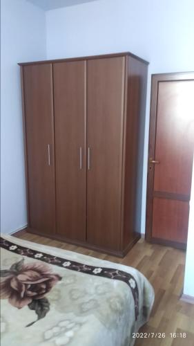 1 dormitorio con 1 cama y armarios de madera en Nairi en Sevan