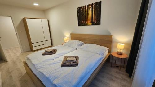 2 room Apartment with terrace, new building, 2BL في براتيسلافا: غرفة نوم عليها سرير وفوط