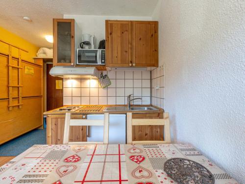 une petite cuisine avec une table dans une pièce dans l'établissement Studio cosy proche des pistes, balcon Sud/Est, navette, local à skis – Val-d'Isère - FR-1-694-86, à Val dʼIsère