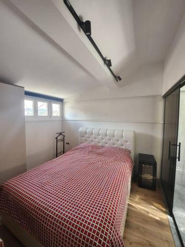 a bedroom with a bed with a red comforter at Maksuzija in Sarajevo