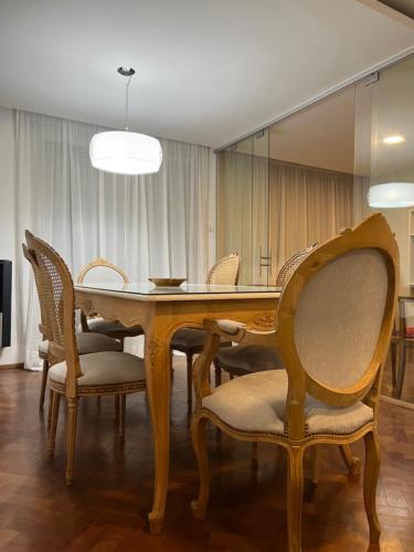 a dining room with a wooden table and chairs at Departamento céntrico 2 dormitorios in San Nicolás de los Arroyos