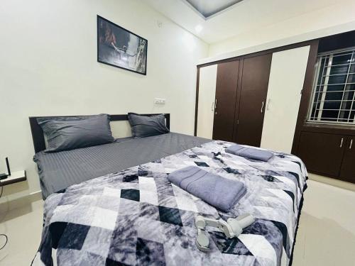 Un dormitorio con una cama con una manta. en Bigson Service Apartments Gachibowli en Hyderabad
