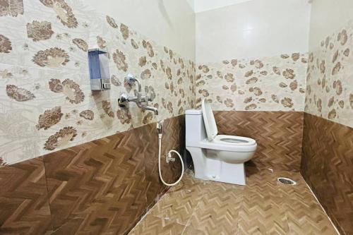 a bathroom with a white toilet in a room at Bigson Service Apartments Gachibowli in Hyderabad