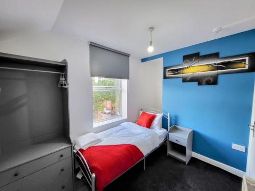 1 dormitorio con cama con almohada roja y ventana en Berridge Solo Stays - NG7 en Nottingham