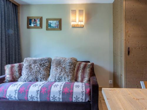 un canapé avec des coussins en fourrure dessus dans une pièce dans l'établissement Studio chaleureux et élégant, front de neige à Val d'Isère, proche centre et pistes - FR-1-694-190, à Val dʼIsère