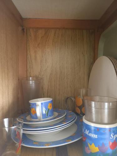 a table with plates and cups on top at Backpack Cabin A 49149 in Oranjestad