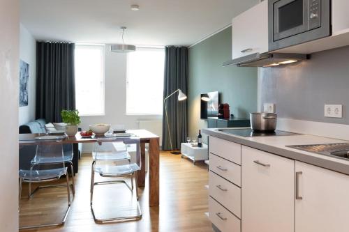 cocina con mesa y sillas en una habitación en Brera Serviced Apartments Nürnberg, en Núremberg