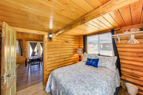 a bedroom with a bed in a log cabin at Cozy Farm Cabin - 9 Mi to Trout Creek! in Trout Creek