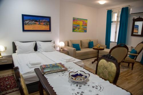 a bedroom with a bed and a table and a couch at Apartman Centar in Sremski Karlovci