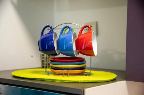 a stack of plates with mugs on top of them at Apartman Centar in Sremski Karlovci