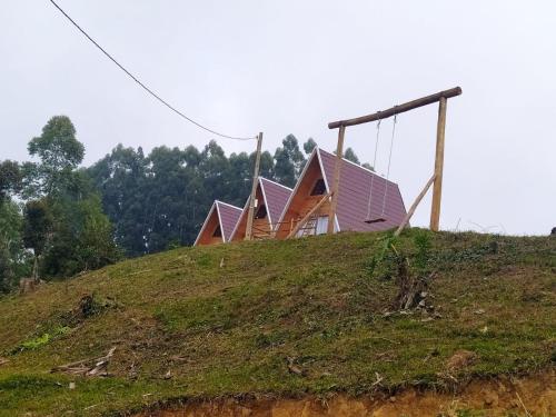 a house on top of a hill with a swing at CascataDiamantePousada in Laurentino