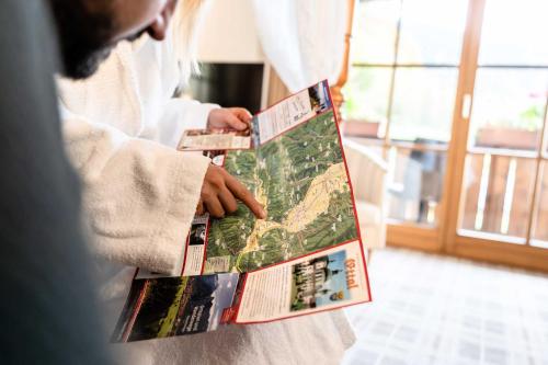 a person holding up a book in a room at Hotel Blaue Gams ***S in Ettal