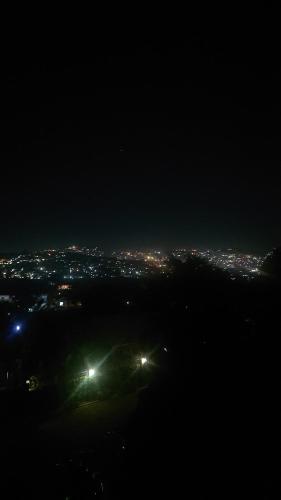 - une vue sur la ville éclairée la nuit dans l'établissement Lajungle Muyenga, à Kampala
