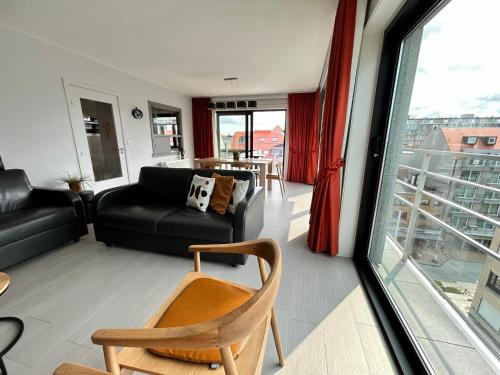 ein Wohnzimmer mit einem Sofa und einem Stuhl in der Unterkunft Sunbeach in Nieuwpoort