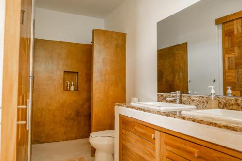 a bathroom with two sinks and a toilet at Villa Bonobo in Puerto Escondido