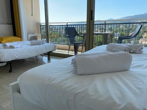two beds in a hotel room with a balcony at Studio Cannes Marina Mandelieu in Mandelieu-la-Napoule