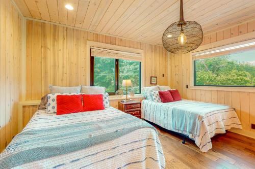two beds in a room with wooden walls and windows at Lefty's in Bentonville