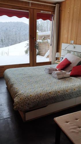 a bedroom with a bed and a window with snow outside at gite haut Jura in Chaux-des-Crotenay