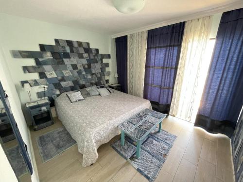 una camera con un letto e una sedia di Fine Art Jeans Apartment ad Arona