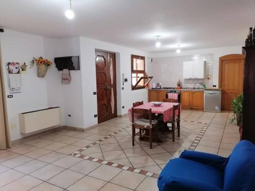 een woonkamer met een tafel en een keuken bij Villa Simone (Cagliari, Escalaplano, Sardegna) 