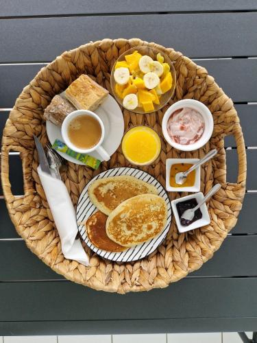 - un panier de petit-déjeuner composé de crêpes et de fruits dans l'établissement Villa Théo , chambre d'hôtes , petit déjeuner, à Sainte-Anne