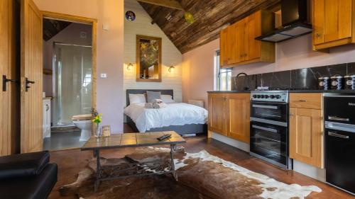 uma cozinha com uma cama e uma mesa num quarto em Lake View Lodges em Long Melford