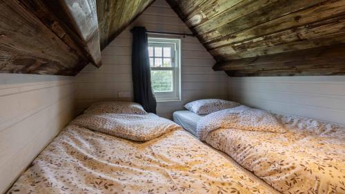 Lake View Lodges في لونغ ميلفورد: سريرين في غرفة صغيرة مع نافذة