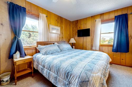 - une chambre avec un lit et une fenêtre avec des rideaux bleus dans l'établissement Salty Paws, à Frisco
