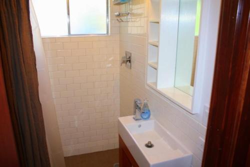 Baño blanco con lavabo y espejo en 1 bedroom, 2 bath, sleeps 4 adults West End of Donner Lake DLR#105 en Truckee