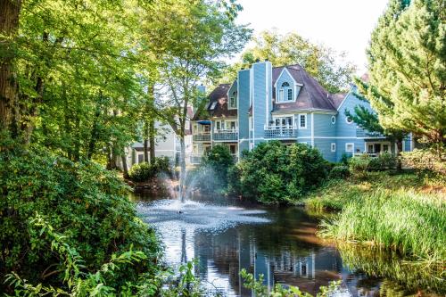 a blue house with a river in front of it at Villa Signor in Norwich
