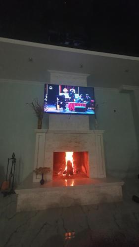 a fireplace with a tv on top of it at Orophile guest house in Gorists'ikhe