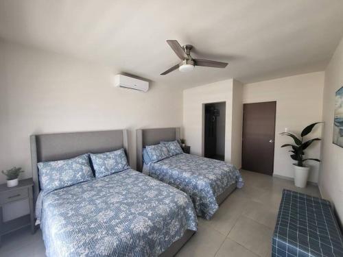 a bedroom with two beds and a ceiling fan at Coral de Cortez - New Beach House in San Carlos