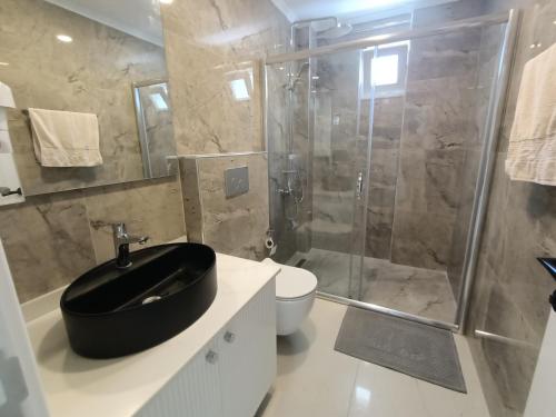 a bathroom with a black sink and a shower at Stylish Flat in the Central Area in Alanya