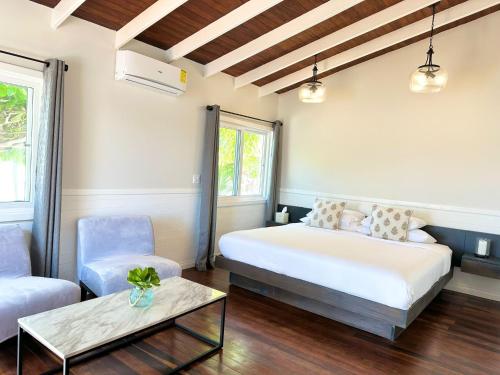 a bedroom with a bed and a couch and a table at Shaka Caye All inclusive Resort in Belize City