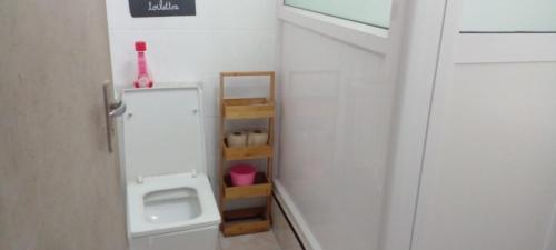 une salle de bain avec une porte blanche avec une étagère à l'intérieur dans l'établissement White appartment, à Flic-en-Flac