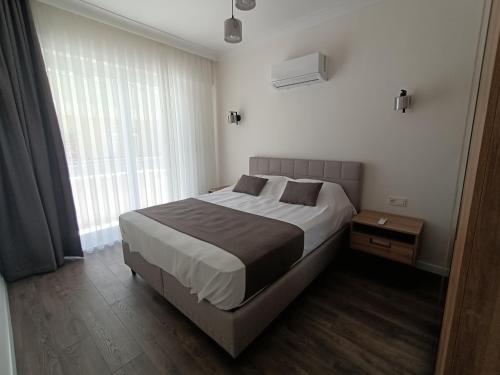 a bedroom with a large bed and a window at Stylish Flat in the Central Area in Alanya
