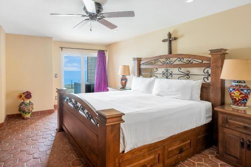 a bedroom with a large bed with a ceiling fan at Solana Shoreside Haven in Solana Beach