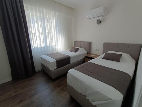 a hotel room with two beds and a window at Stylish Flat in the Central Area in Alanya