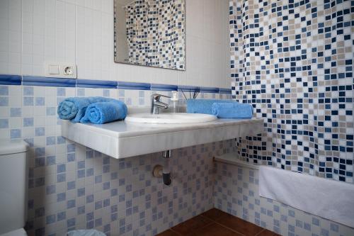a bathroom with a sink with blue towels on it at VILLA ADELA in Callao Salvaje