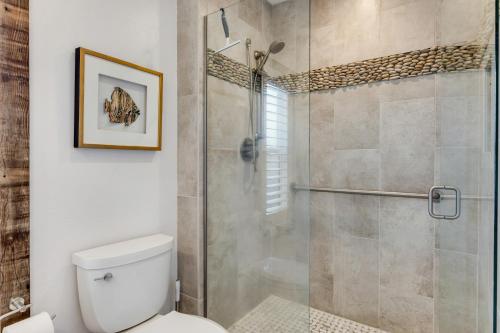 a bathroom with a toilet and a glass shower at Monterey Dune Haven in Moss Landing