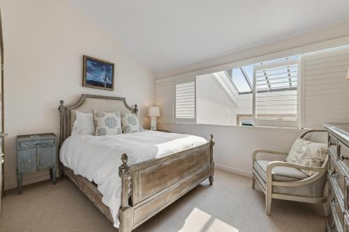 a bedroom with a bed and a chair and a window at Monterey Dune Haven in Moss Landing