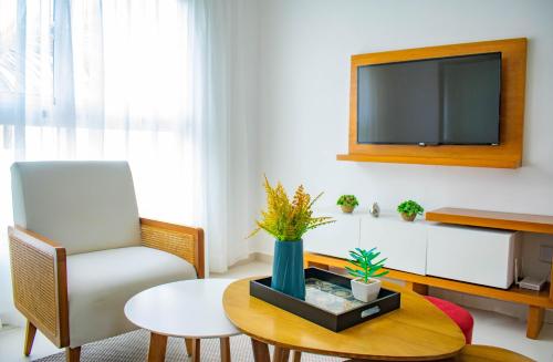 a living room with a tv and a chair and a table at Playa Palmera Beach Resort in Punta Cana