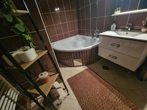 a bathroom with a bath tub and a sink at Apartman Samantha in Vinkovci