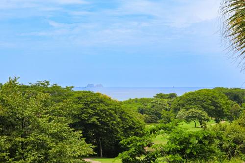 a view of the ocean through the trees at Bougainvillea 2101 in Playa Conchal