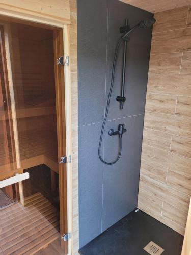 y baño con ducha y puerta de cristal. en Domek w Paszynie - Sauna i Gorąca balia, en Paszyn