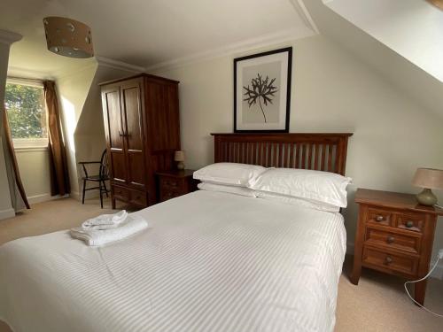 a bedroom with a large bed with white sheets at Bracken Cottage in Killean