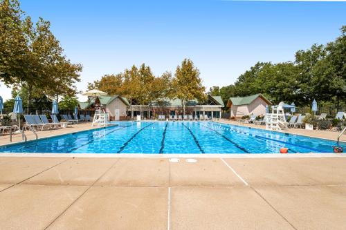 a large swimming pool with chairs and umbrellas at Bear Trap Dunes---26 Willow Oak Ave in Ocean View