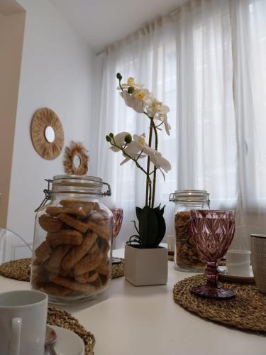 une table avec un pot de biscuits et un vase de fleurs dans l'établissement Noh collection 3BDR apartment- Trastevere Area, à Rome