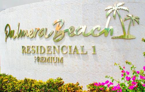 a sign for a hotel on a wall with flowers at Playa Palmera Beach Resort in Punta Cana